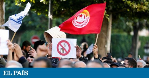 Protestants holding UGTT union flags and boards against IMF