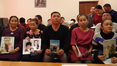 In this Dec. 7, 2018, relatives of people missing in China's far western region of Xinjiang hold up photos at an office of a Chinese Kazakh advocacy organization in Almaty, Kazakhstan. Dake Kang/AP