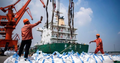 Workers unload bags of chemicals at a port in China's eastern Jiangsu province on Aug. 7, 2018. Photo: Johannes Eisele / AFP/Getty Images file