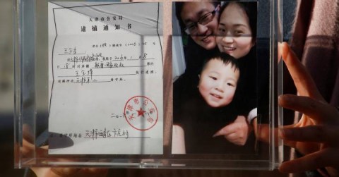 Li Wenzu, wife of the jailed attorney Wang Quanzhang holding a familiy photo.