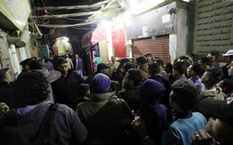 Police officers control the crowd at the scene where policemen were killed when an explosive device carried by a militant they were pursuing exploded in Cairo, Egypt