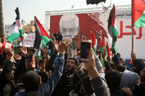 Palestinians hold signs that read 