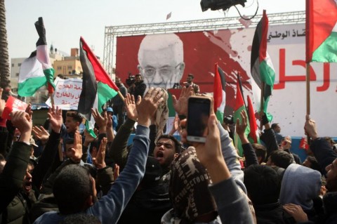 巴勒斯坦人在星期天在加沙城要求巴勒斯坦權力機構主席阿巴斯下台的抗議活動中持有“離開”的跡象。