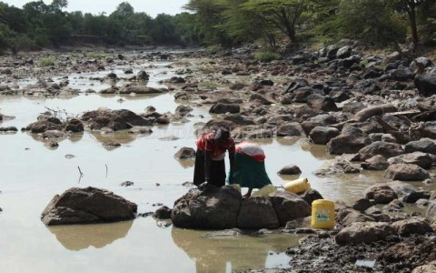Women fetch water at Mara River which is almost drying up following prolonged drought.