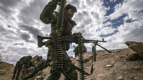A SDF soldier carries a machine gun at a position close to ISIL-held Baghouz village on Sunday [Delil Souleiman