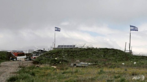 以色列國旗飛越敘利亞邊境圍欄附近的一個軍事基地，在以色列吞併的戈蘭高地，在德魯茲Majdal Shams村以南。