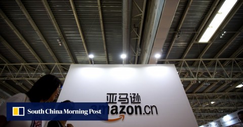 Visitors walk past a logo for Amazon China at the Beijing International Book Fair in 2017.