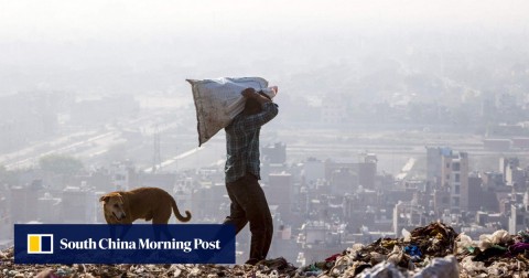 A rag picker carries a sack of sorted recyclable materials atop the Ghazipur landfill site in the east of New Delhi. 
