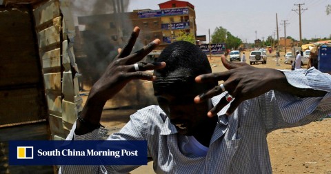 A Sudanese protester runs past a barricade in Khartoum. 