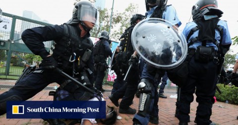 Police in full riot gear restrain a protester outside Legco on Wednesday.