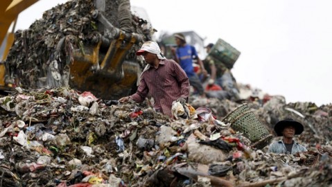 人們在垃圾桶中尋找回收材料。