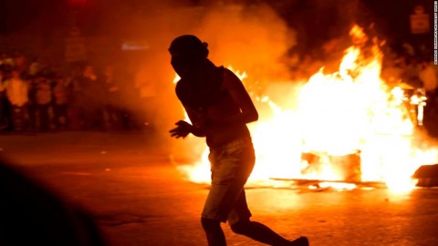 A protester runs past a burning barrier at the main entrance to Jerusalem.