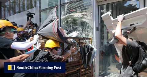 Protesters smash glass panels of the Legislative Council Complex in Tamar during a protest against the extradition bill.