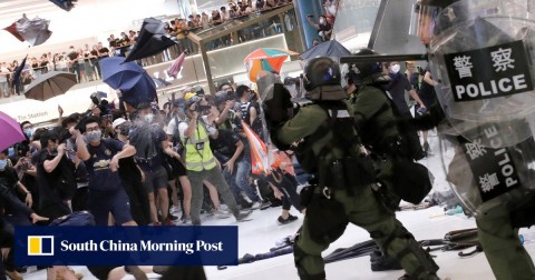 防暴警察使用胡椒噴霧驅散香港的抗議者，他們帶著雨傘和瓶子回火。