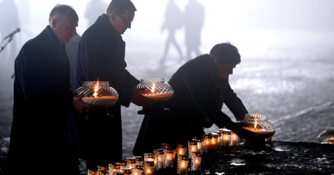 Polish Prime Minister Mateusz Morawiecki (c), Deputy Prime Minister Beata Szydło (r) and Undersecretary of State Wojciech Kolarski (l) light candles at the International Monument to the Victims of Fascism. Photo: Stanislaw Rospedzik/EPA