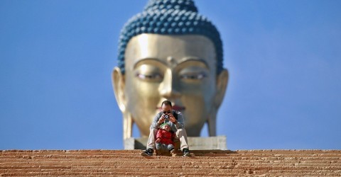 A man takes a photograph in front of the Buddha Dordenma statue in Bhutan on December 16, 2017. Photo: Cathal McNaughton/Reuters