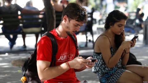 Miguel Hayes, who writes for the blog La Joven Cuba, connects to the internet at a hotspot in a park, in Havana, Cuba, Feb. 5, 2018. Photo: Reuters
