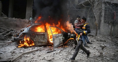 A Syrian Civil Defense member carrying a wounded child in the besieged town of Hamoria, in Eastern Ghouta, last month. Photo: Bassam Khabieh/Reuters