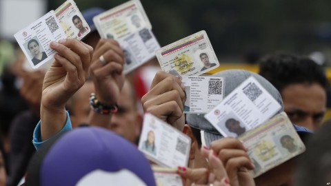 Venezuelan citizens hold up their identification cards for inspection by the Colombian immigration police, in Cucuta, Colombia, on the border with Venezuela, Feb. 22, 2018. Photo: AP
