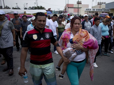 Central American migrants and their child who participated in the annual Migrants Stations of the Cross caravan walk to the Basilica of Guadalupe after the caravan arrived to a shelter in Mexico City, Monday, April 9, 2018. Photo: Eduardo Verdugo