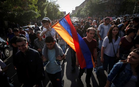 A boy holds a national flag during a rally of Armenian opposition supporters in Yerevan, April 30, 2018. Photo: Gleb Garanich / Reuters