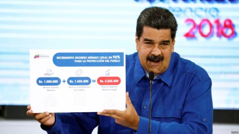 Venezuela's President Nicolas Maduro holds a poster explaining the new minimum wage as he speaks during a news conference in Caracas, April 30, 2018.  Photo: Reuters