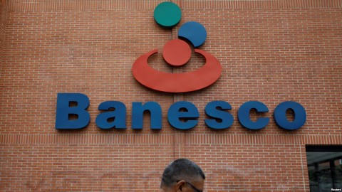 A man walks past the corporate logo of Banesco bank at one of its branches in Caracas, Venezuela, May 3, 2018. Photo: Reuters