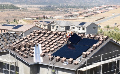 A worker sets a final photovoltaic panel in place atop a house in KB Home’s Caraway at Terramore development south of Corona. Photo: Will Lester / The Press-Enterprise/SCNG